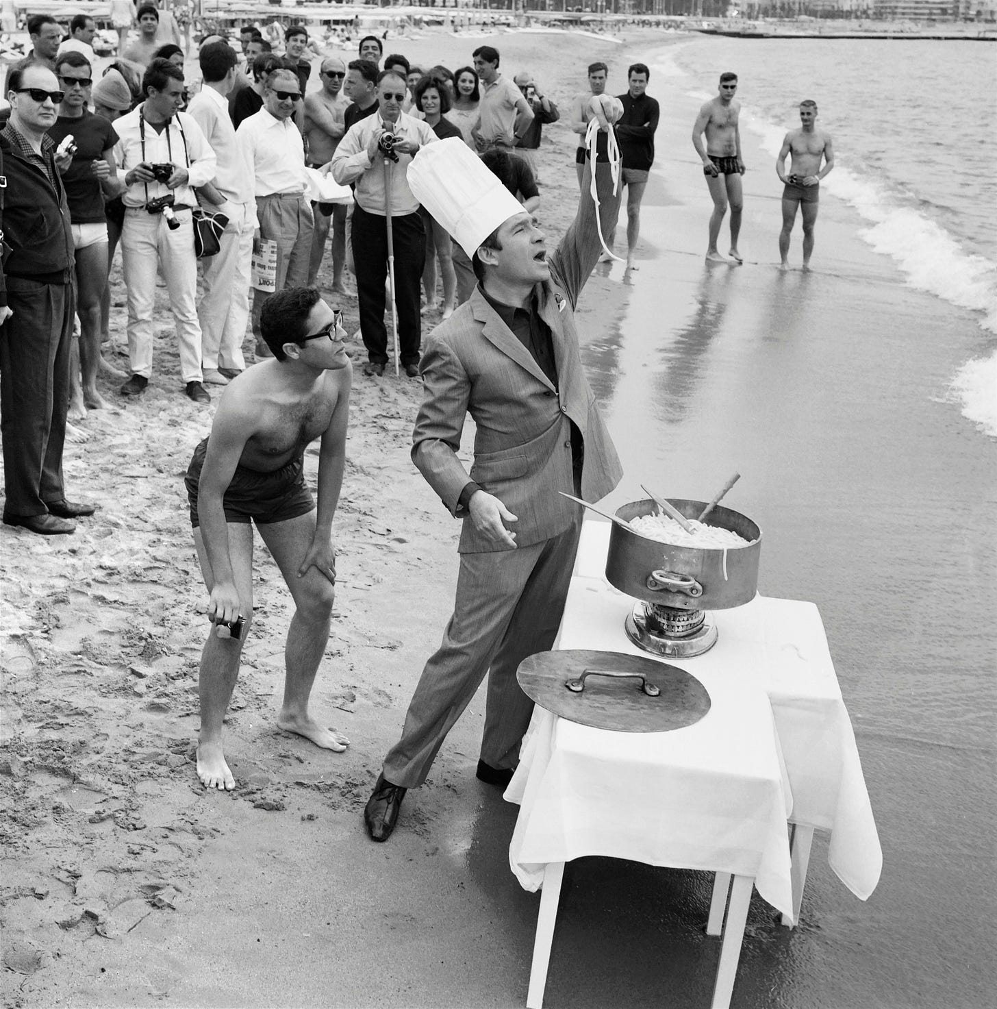 Italian actor Ugo Tognazzi is cooking on the beach during the 15th Cannes Film Festival in Cannes, on May 2, 1964. 