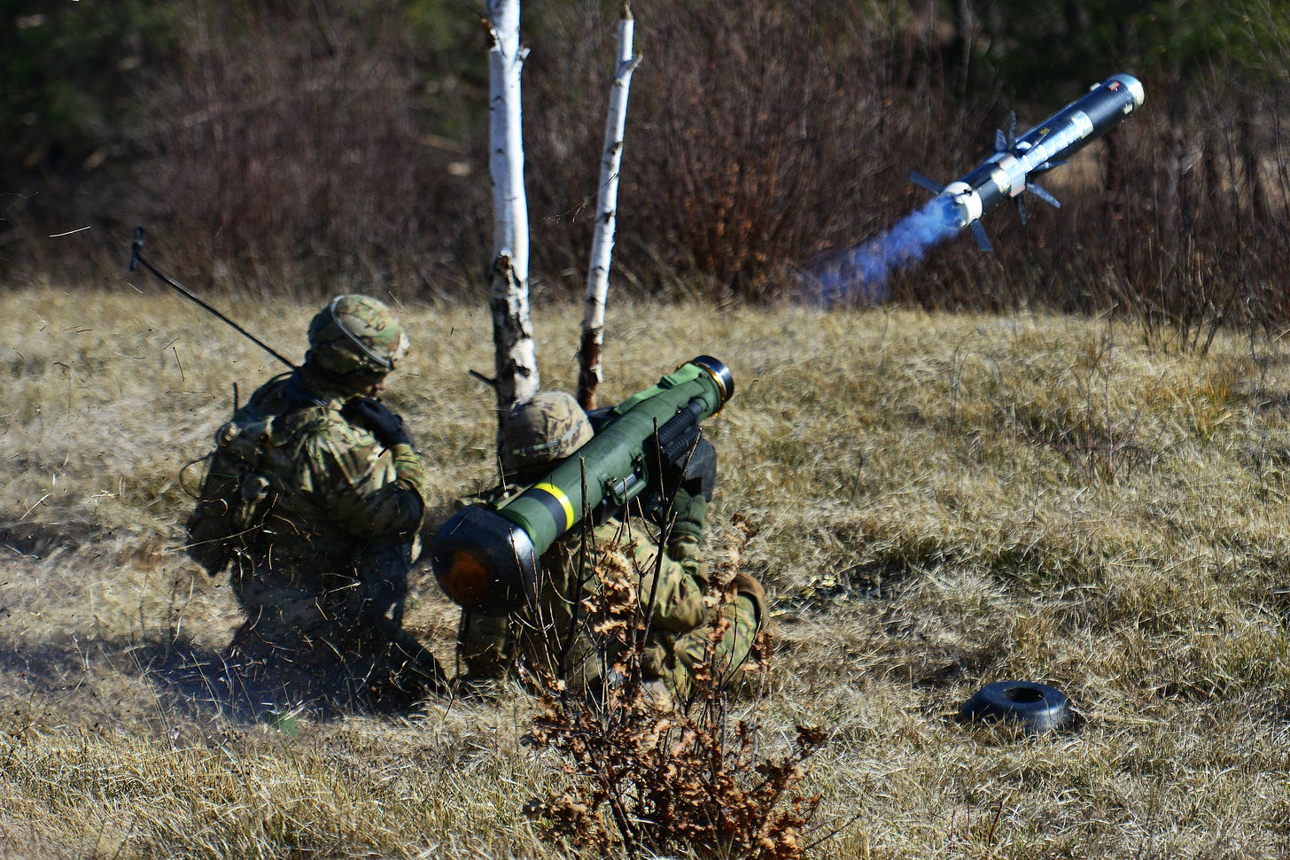 Two soldiers fire off a missile into the distance.