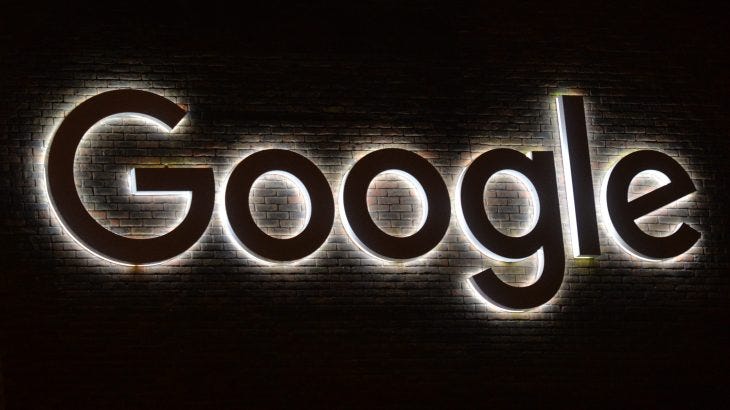 Google logo sign with white backlighting on dark background
