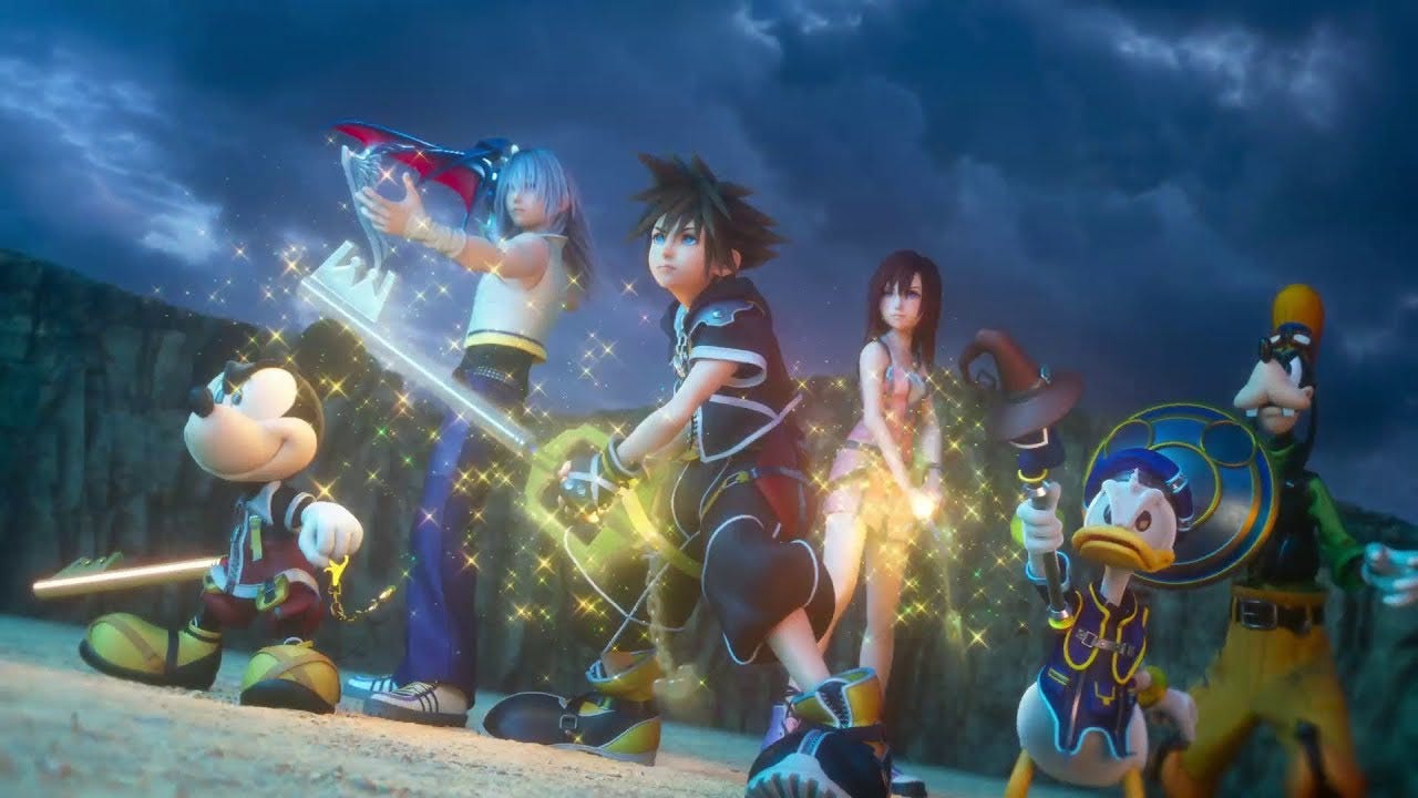 A motley group of characters brandish their weapons and face some offscreen threat. In the center is a boy with spiky brown hair and baggy clothes holding a giant key; surrounding him are Mickey Mouse, also holding a key; another both with long white hair and a sword shaped like a bat wing; a girl with shoulder-length red hair; Donald Duck weilding a magic wand; and Goofy holding a shield with an emblem in the shape of Mickey Mouse's head. They stand on a large dirt plain surrounded by tall rock walls, dark storm clouds looming overhead. There are magic sparkles everywhere.