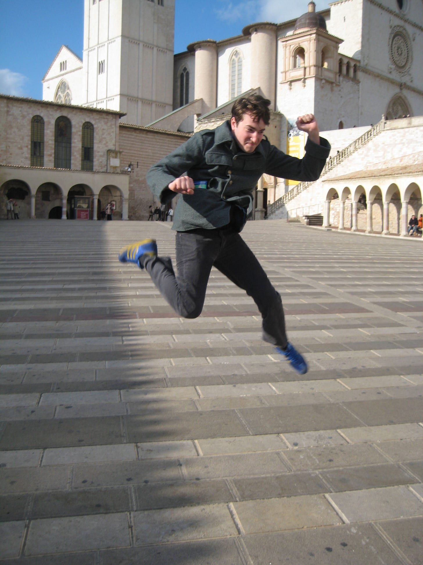 A picture of college-age me jumping in front of a stately Italian basilica.