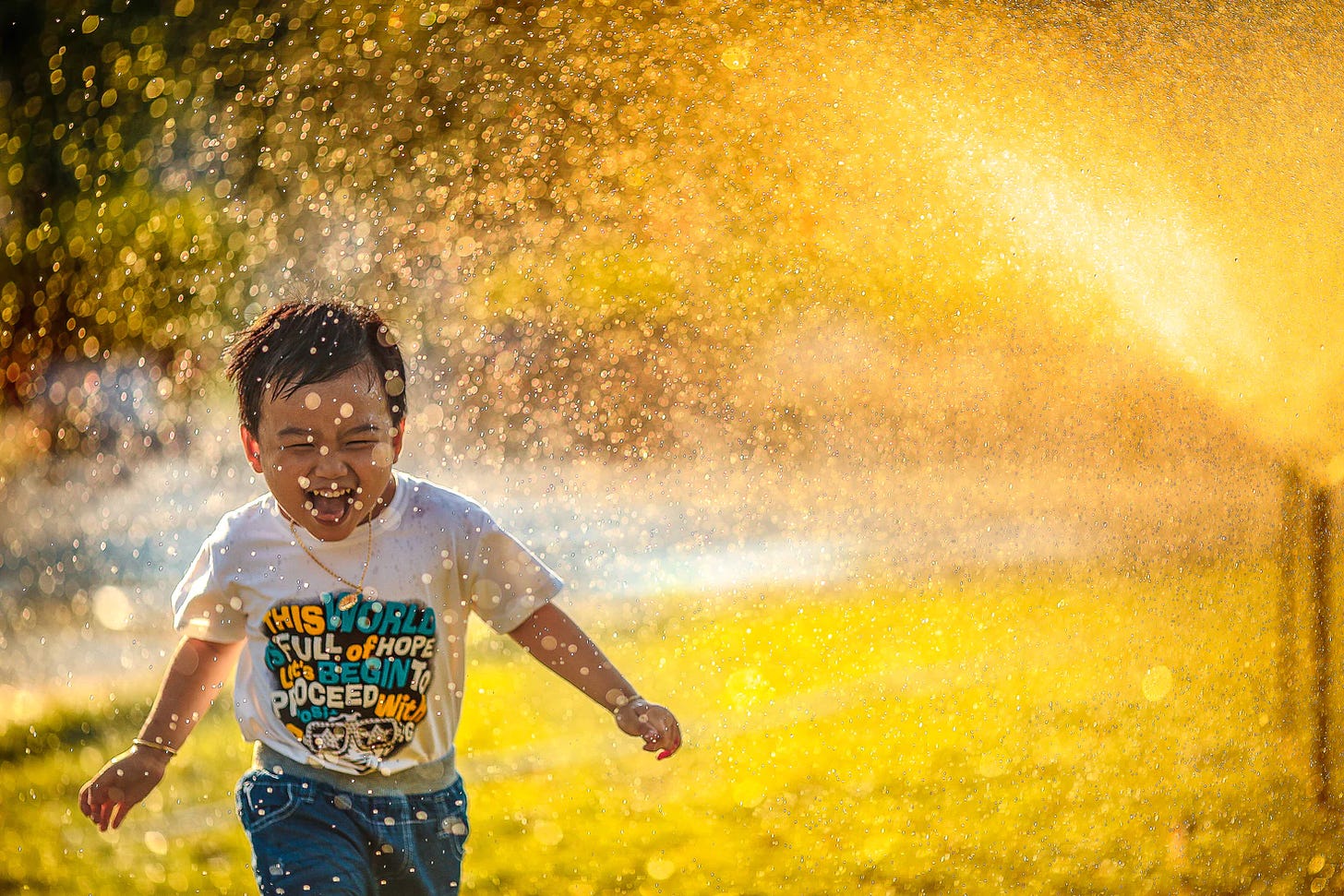 Little boy playing in water and sunshine. 