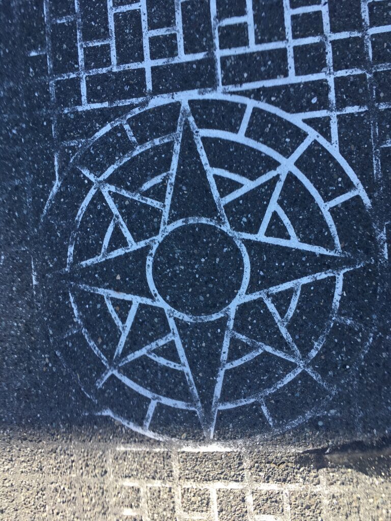Crosswalk pattern on pavement in Bellingham, white brick pattern with a compass rose