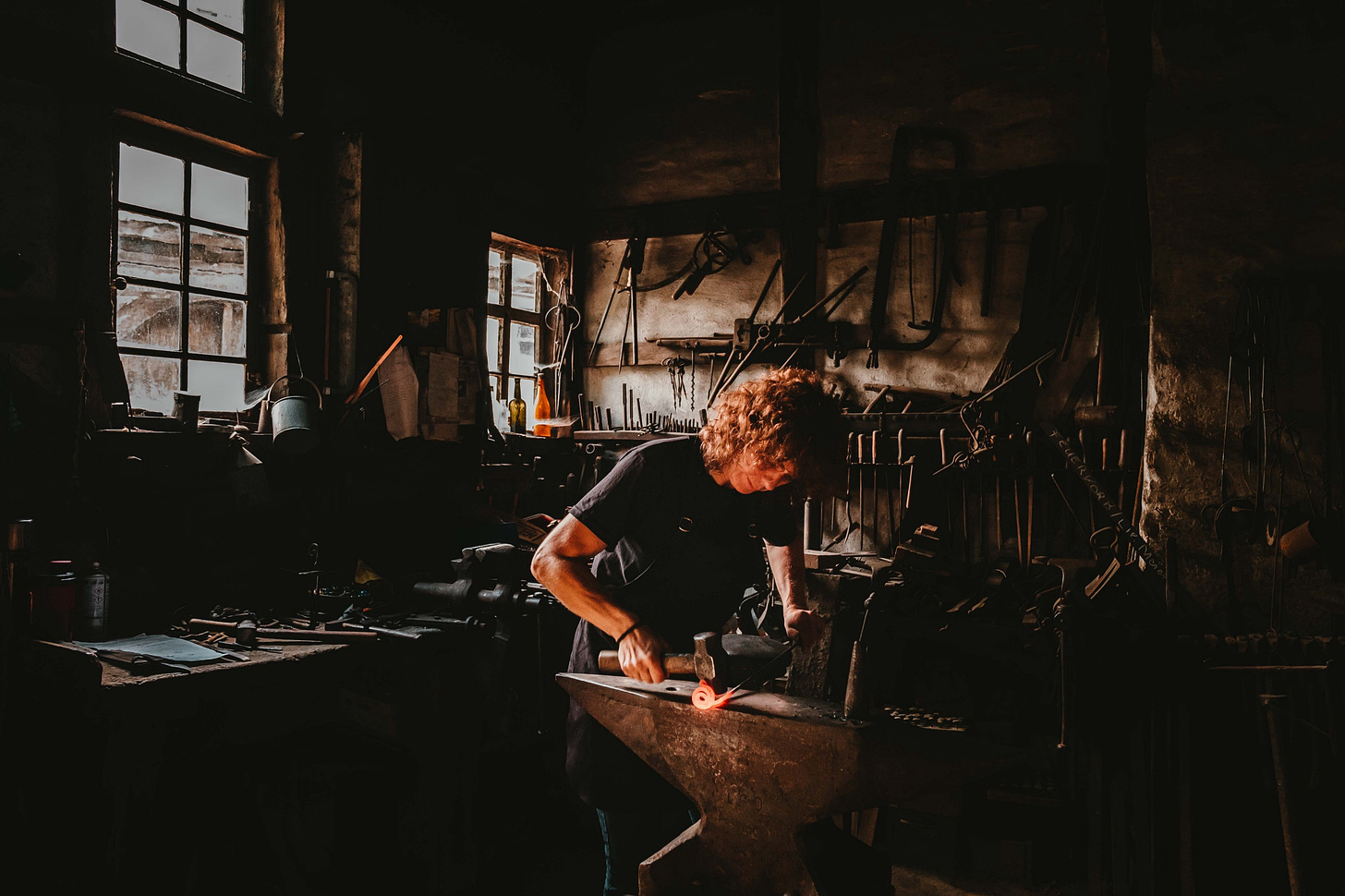 image of a blacksmith working in a workshop for article by Larry G. Maguire