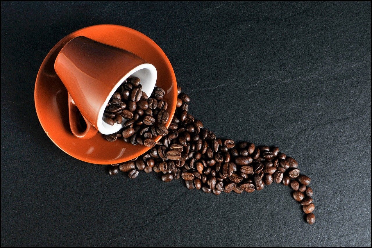 tipped coffee cup spilling out beans