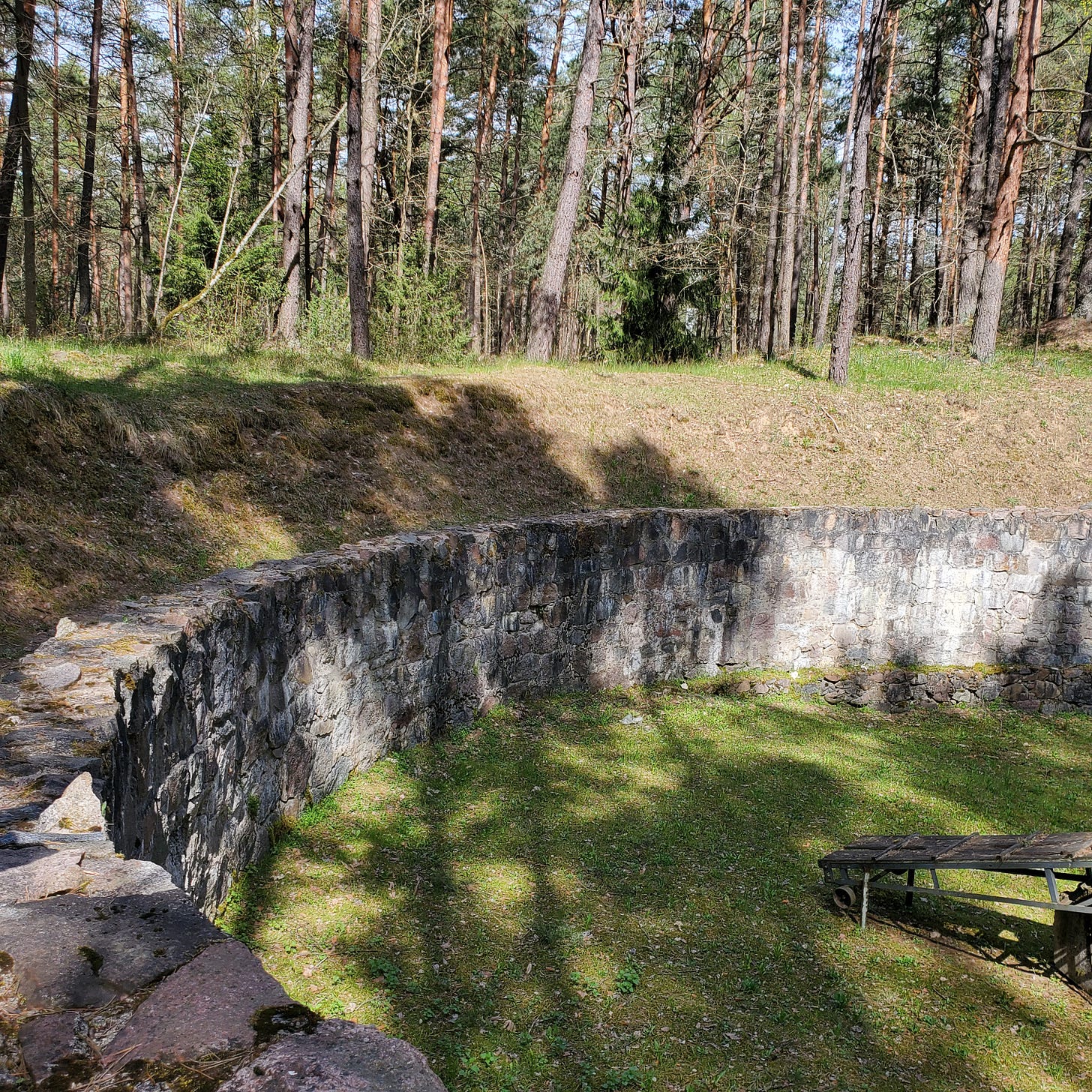 A pit surrounded by a stone wall, about 4 meters high.