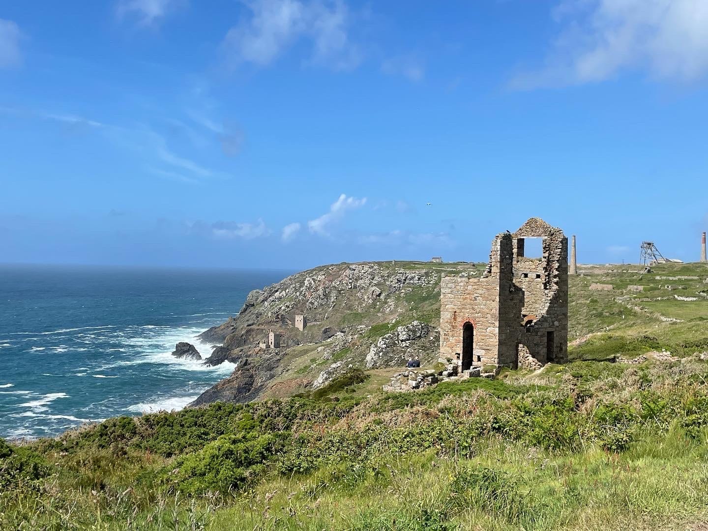 Colour photo of the Cornwall coast with the ruins of Wheal Edward mine in the foreground and Botallack mine in the distance 