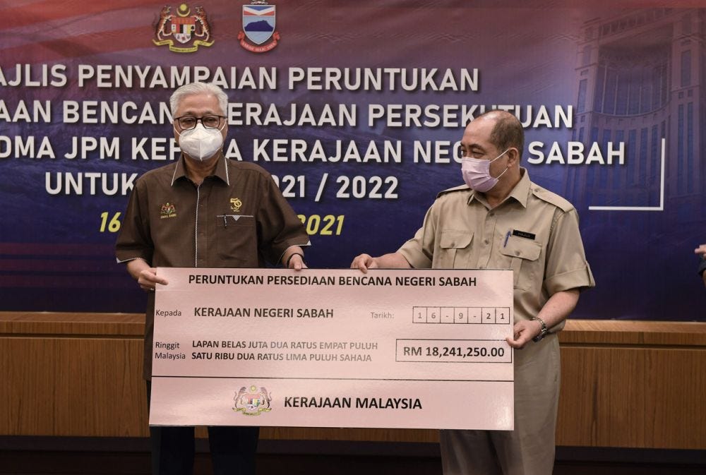 Prime Minister Datuk Seri Ismail Sabri Yaakob (left) hands over a mock cheque to Sabah Chief Minister Datuk Hajiji Noor in Kota Kinabalu September 16, 2021. ― Bernama pic
