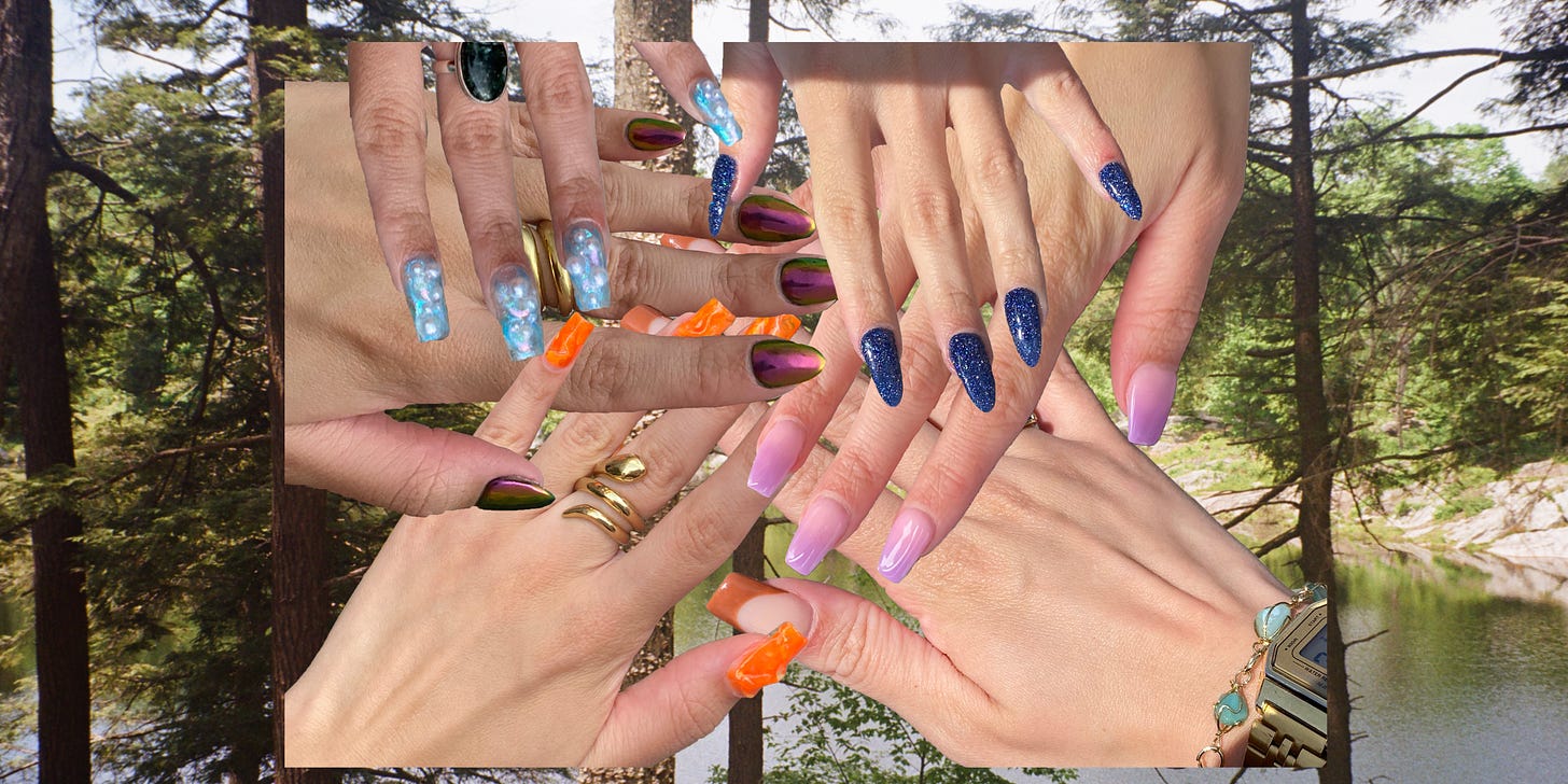 Six hands placed over each other displaying gel manicures in different colors and textures. Behind the hands is a view of trees and a quiet lake.
