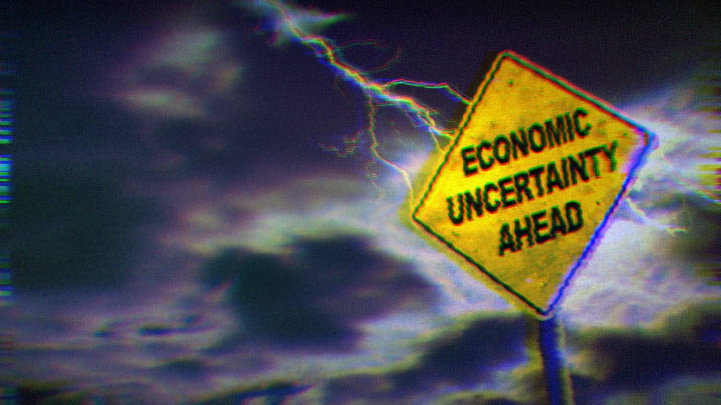 Lightning hitting a yellow road sign that says 'economic uncertainty ahead.'