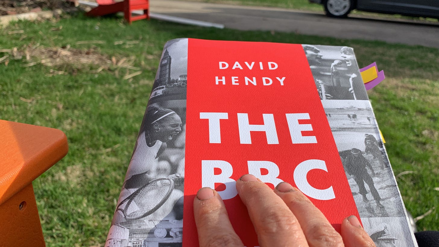 A book about the BBC, with a very dirty hand resting on top.