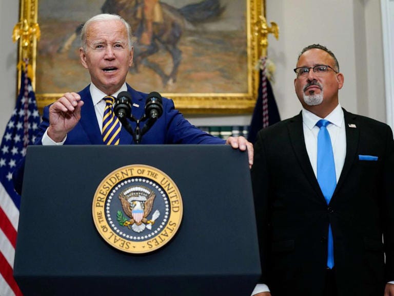 President Joe Biden speaks about student loan debt forgiveness with Education Secretary Miguel Cardona in the Roosevelt Room of the White House, Aug. 24, 2022.
