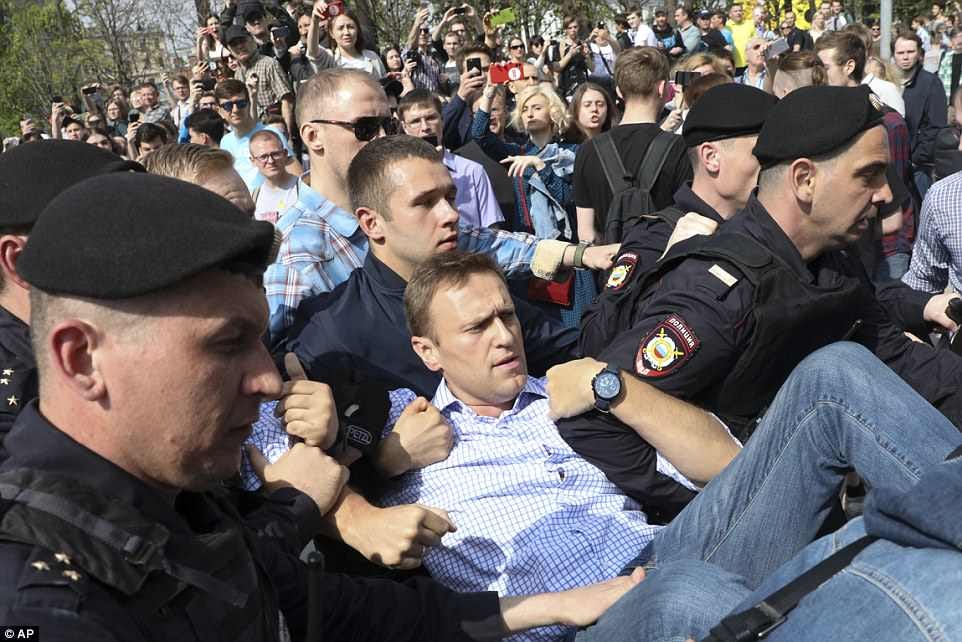 Russian police carrying struggling opposition leader Alexei Navalny, center, at a demonstration against President Vladimir Putin 