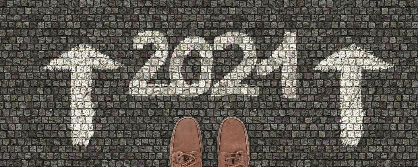 2021 written in white with arrows on a gray paving. Shoes ready to step into the new year. What will the new year bring?