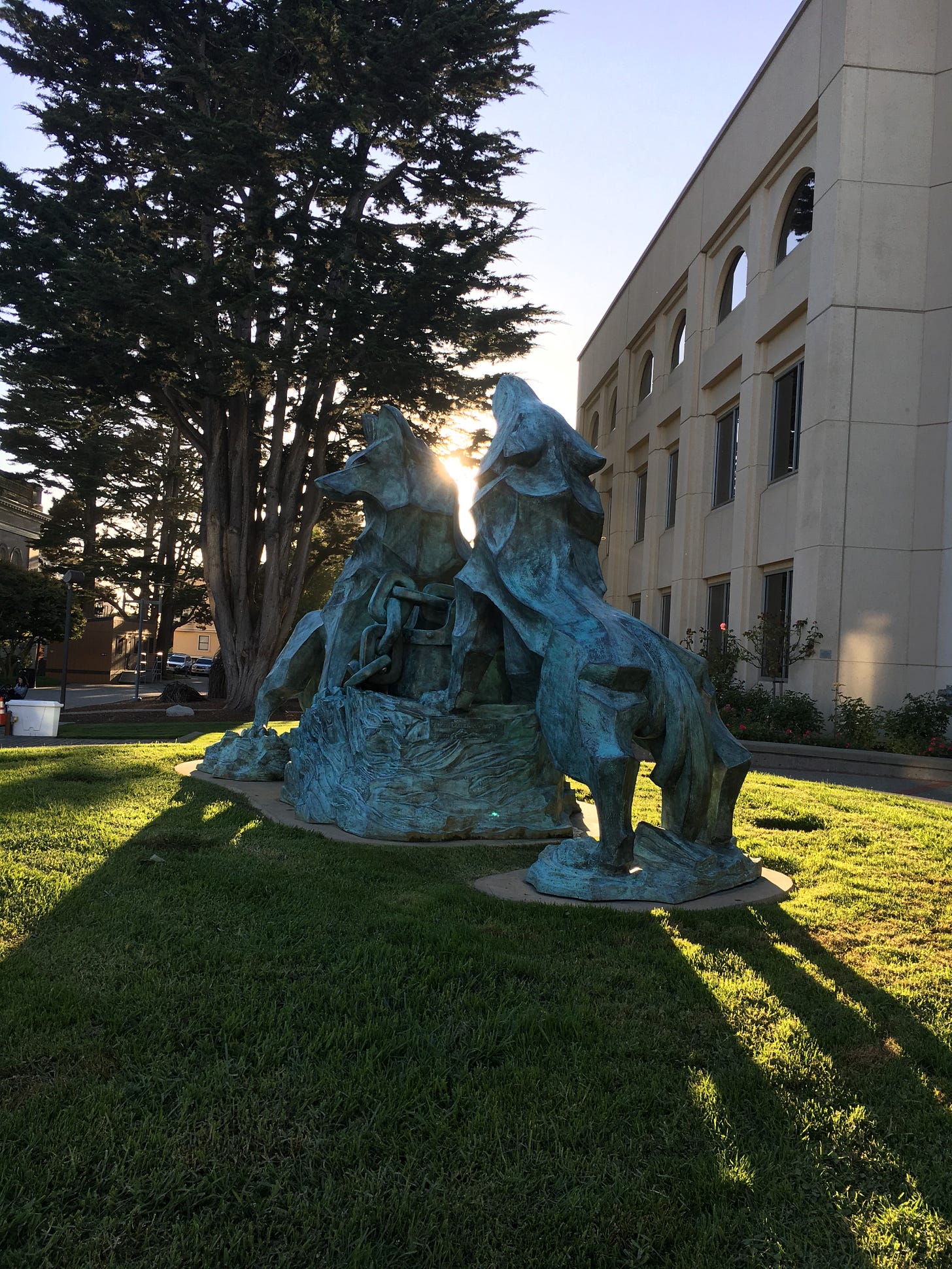 A statue of two wolves howling in front of the library at the University of San Francisco