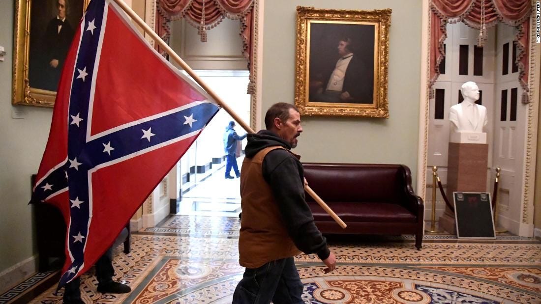 Man carrying Confederate flag inside the US Capitol during riot arrested, identified as Kevin ...