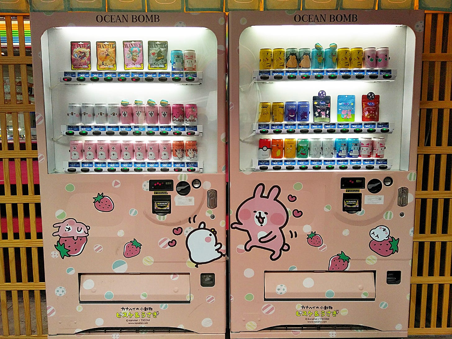 Two Japanese-style vending machines side by side decorated with animated characters and strawberries.