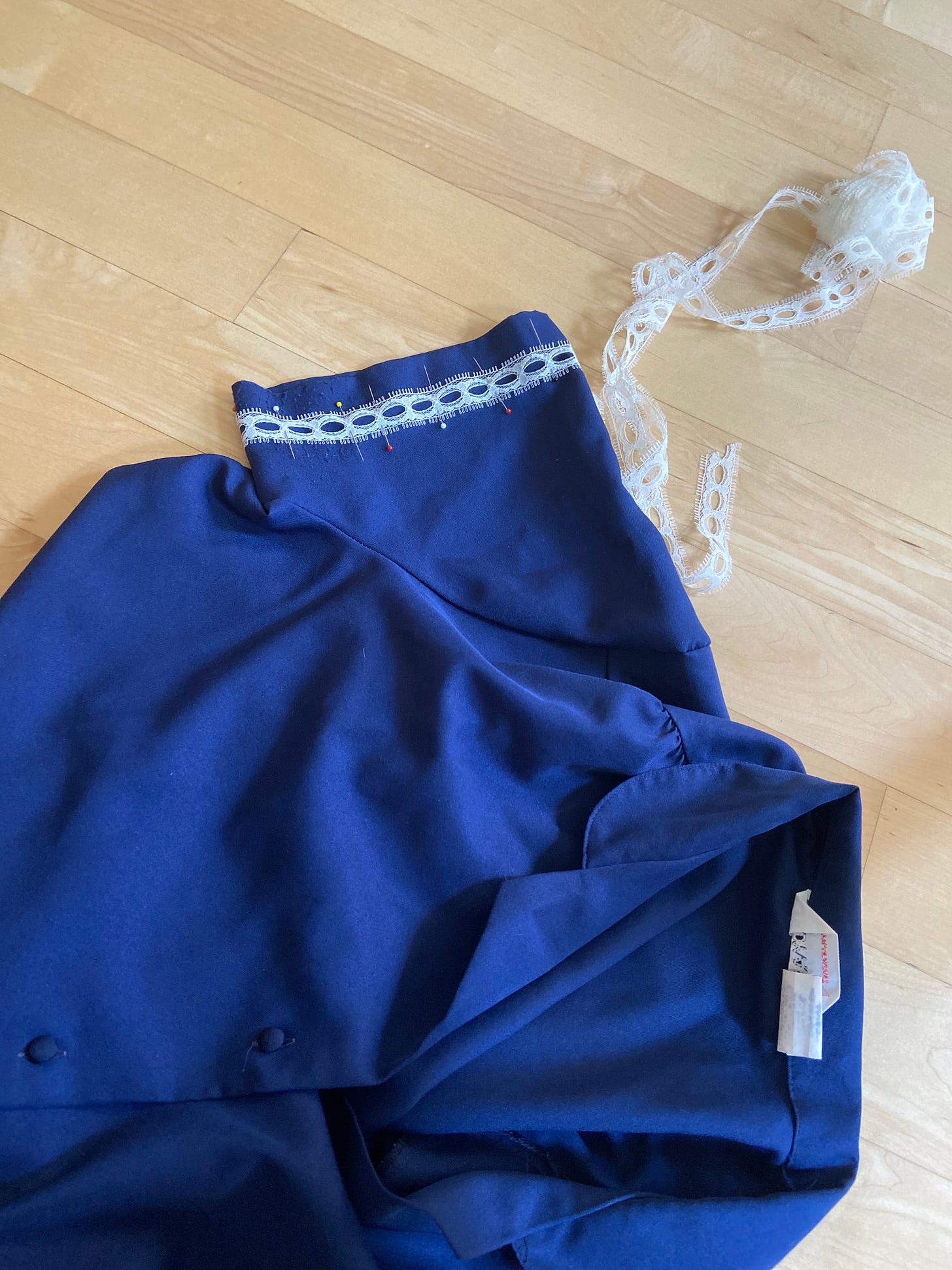 a blue short sleeved button up with lace pinned to the sleeve cuff.