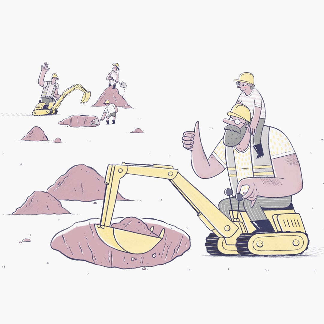 A man sits with his son on a small yellow digger. He waves to another father, digging with his son and daughter in the distance. A man sits with his son on a small yellow digger. He waves to another father, digging with his son and daughter in the distance.
