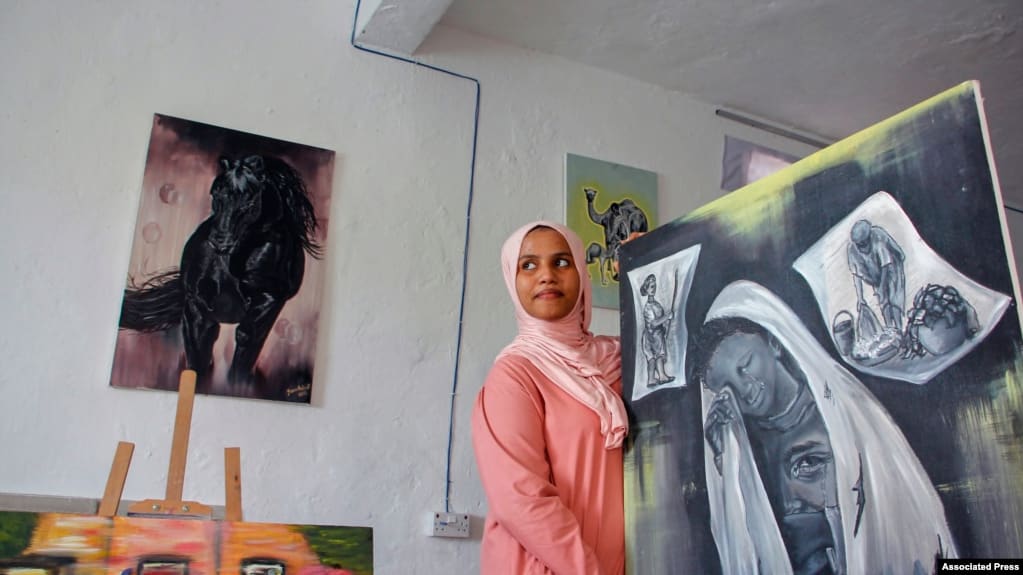 Somali artist Sana Ashraf Sharif Muhsin, 21, displays some of her paintings at her home in the capital Mogadishu, Somalia, Oct. 15, 2021. 