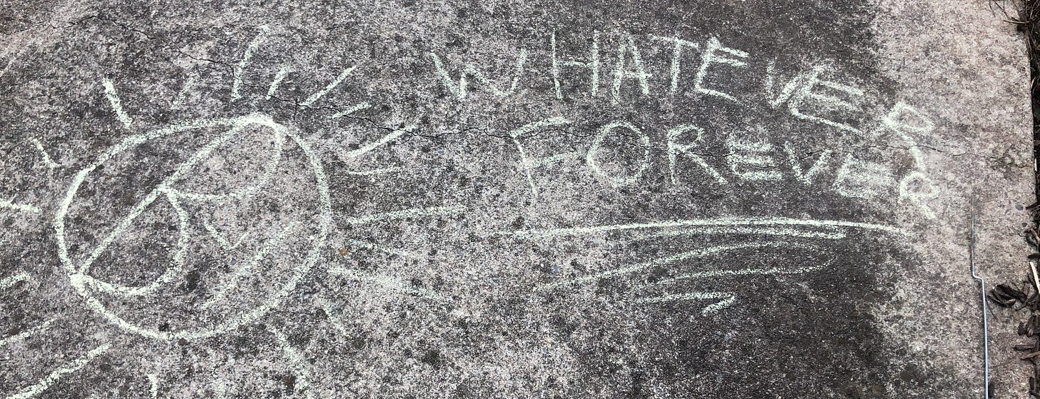 Sidewalk chalk that reads "whatever forever."
