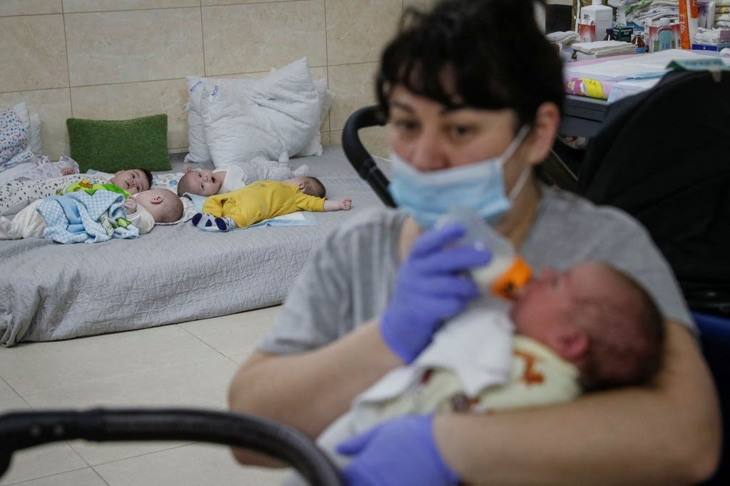 Nurse Oksana Martynenko feeds a surrogate-born baby.