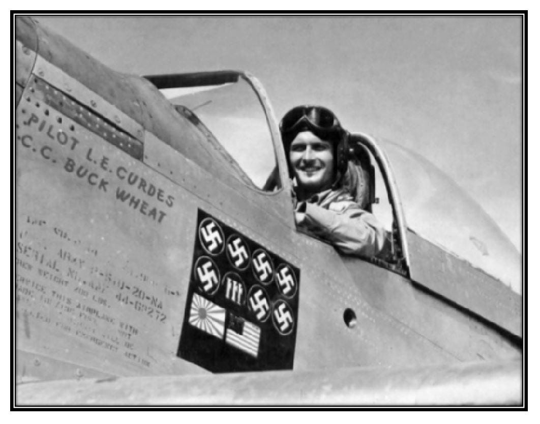 Louis Edward Curdes smiles as he sits in the cockpit of his plane.  Nazi swastikas, an Italian insignia, a Japanese flag, and an American flag have all been painted on his plane.