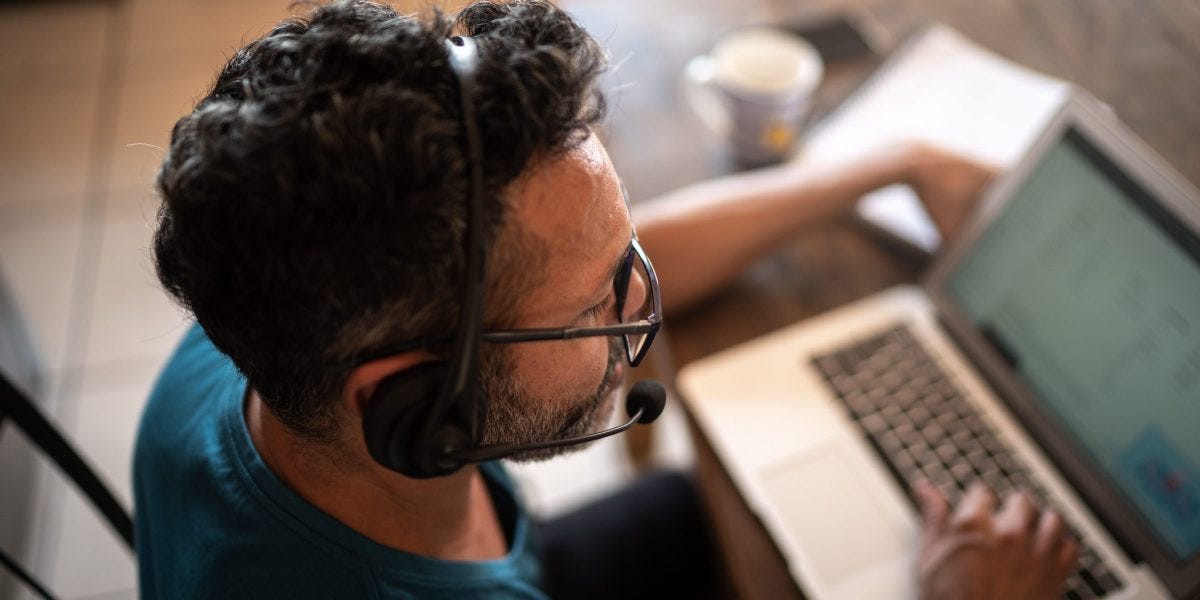 Person working from home or is on a customer call with a headset and laptop