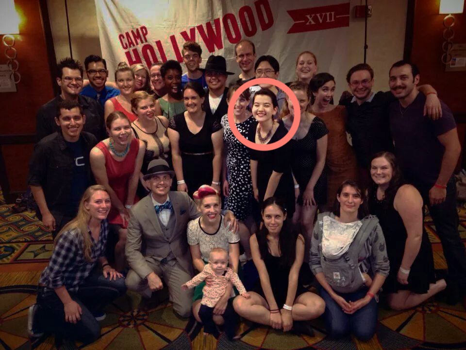 Jessie standing in a group of other swing dancers. A red circle is overlaid to highlight her face.