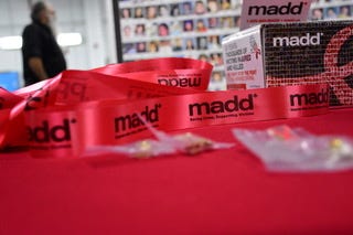 MADD red ribbon on a red table.