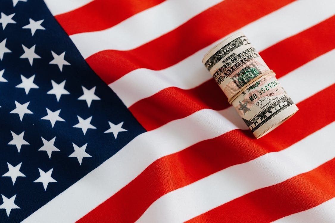 Free From above of United States currency folded in roll placed on USA flag illustrating concept of business profit and wealth Stock Photo