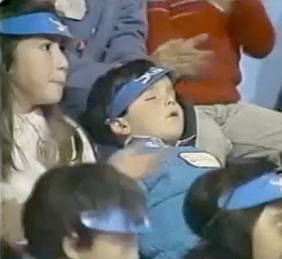 sleeping child in a group of cheering kids