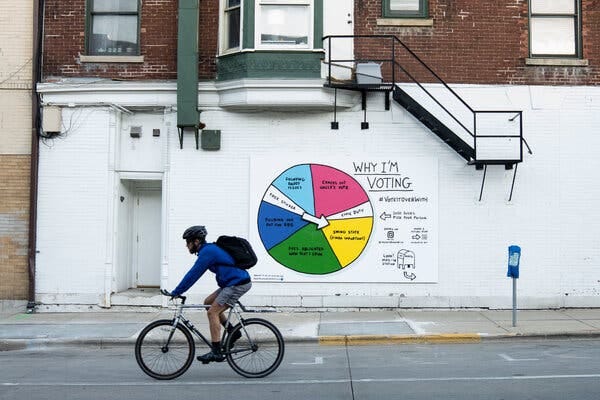 An interactive mural near State Street allows voters to spin the wheel and claim their reason for voting in Madison, Wisconsin.