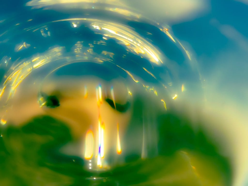 close up photo of a blue and green liquid in a wine glass