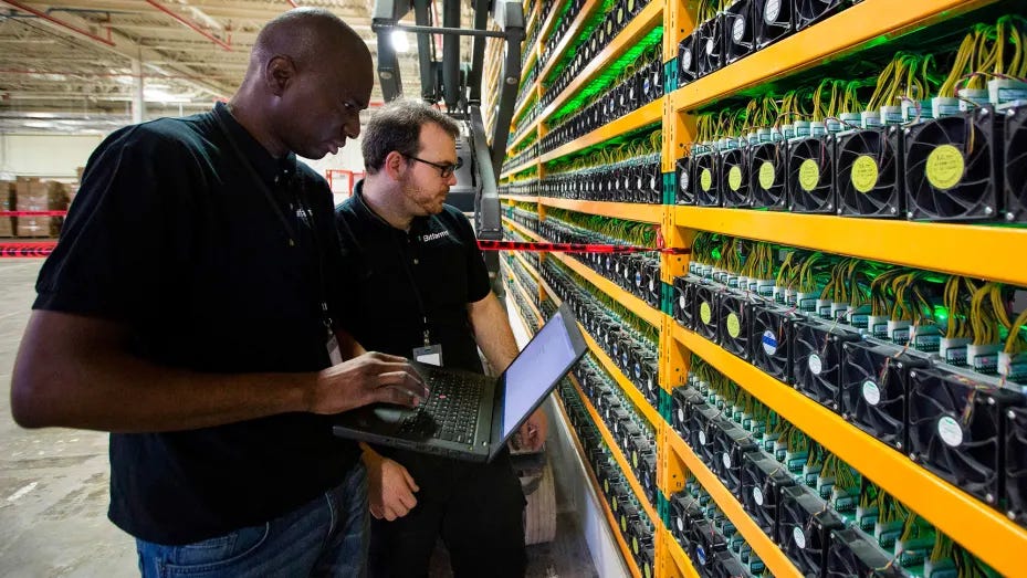 Two technicians work at a bitcoin mining facility in Quebec.