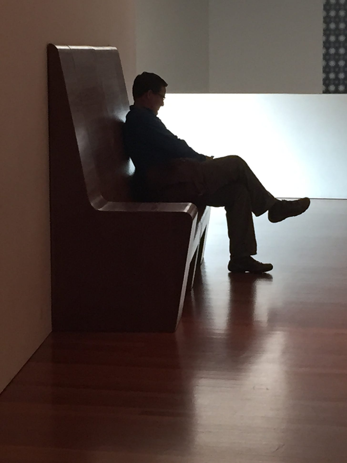 Man sitting on bench in museum
