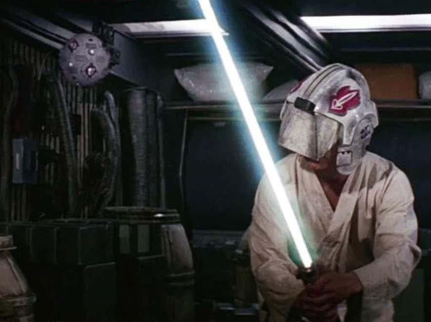A person wearing a helmet and holding a light saber

Description automatically generated with low confidence