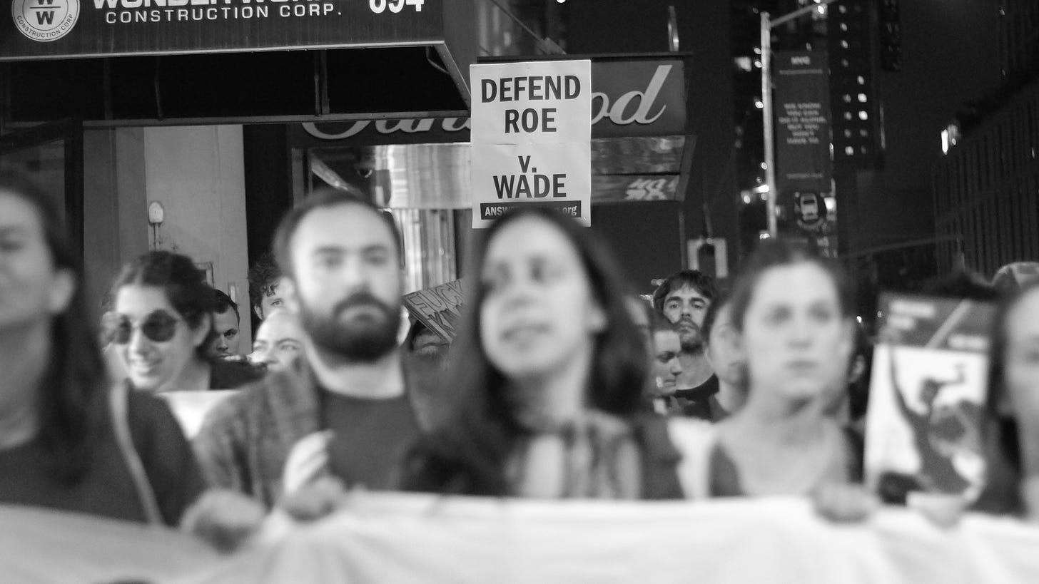 Black and white photo of marchers protesting in defense of Roe v. Wade