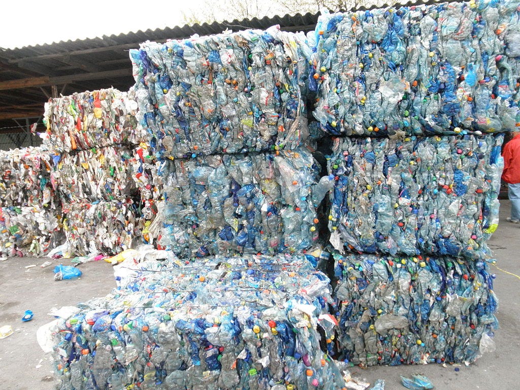 bales of crushed PET bottles and other baled plastics at a recycling facility.