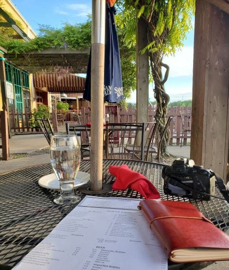 photo of a menu and glass of water on a table at a outdoor restaurant patio