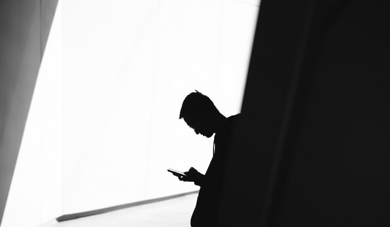Silhouette of a man using his phone