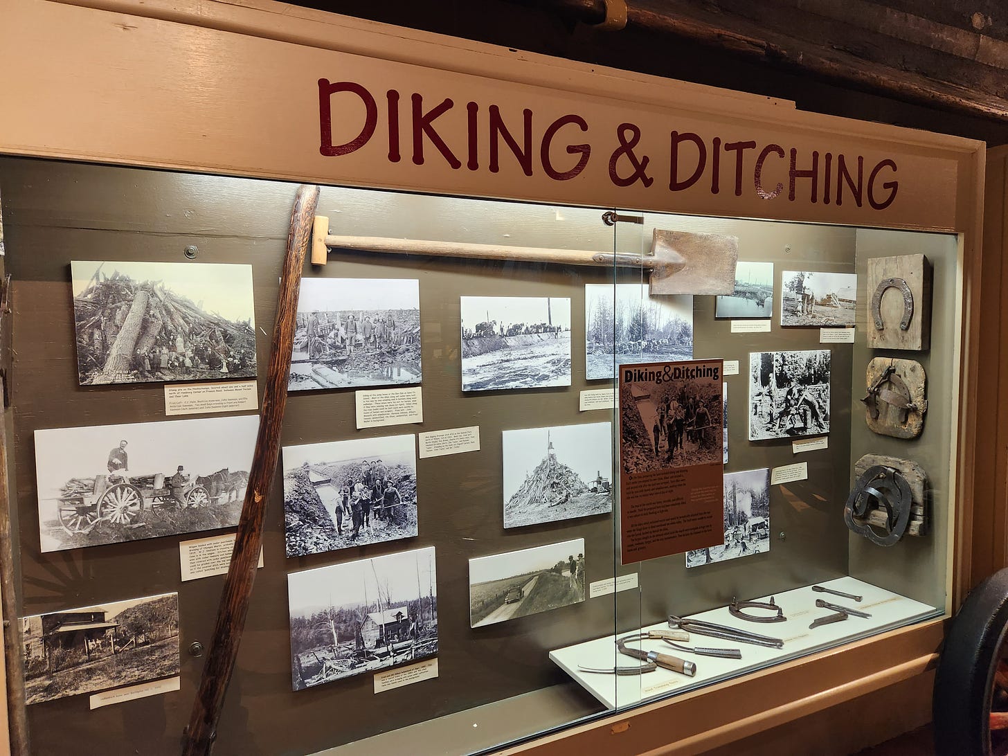museum display with tools and photos about diking and draining the land