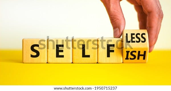Selfish or selfless symbol. Businessman turns cubes and changes the word 'selfish' to 'selfless'. Beautiful white background, copy space. Business, psuchological and selfish or selfless concept.