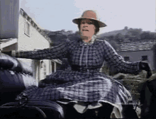 gif of a woman in a large plaid dress fainting backwards out of an open carriage