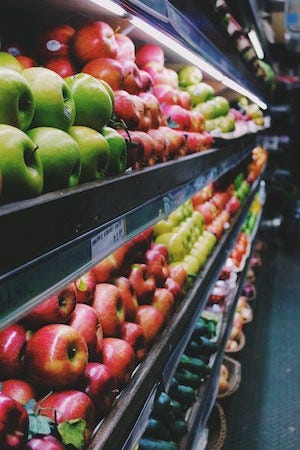 Image of a supermarket aisle of apples on article by Larry G. Maguire