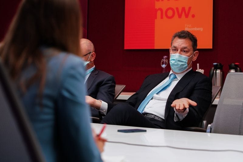 Pfizer chief executive Albert Bourla wears a mask while speaking with Bloomberg reporters in a red conference room