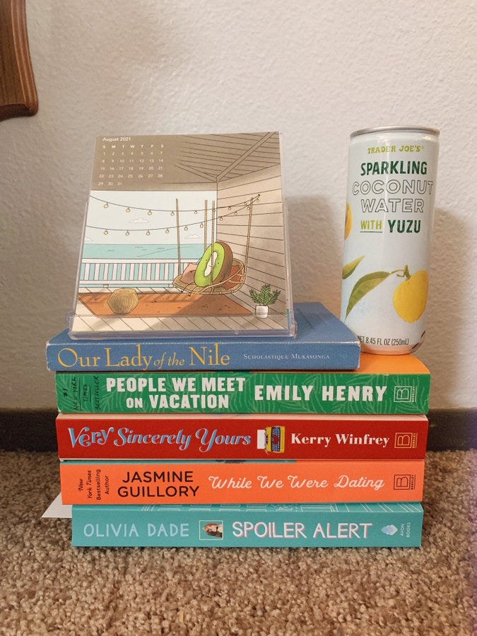 stack of books with a can of sparkling coconut water on top and a calendar showing August 2021