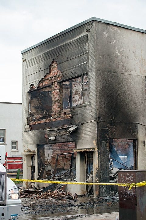 Minnesota, USA — Protest and riot aftermath on East Lake Street. Burned brick building, tardis shaped.