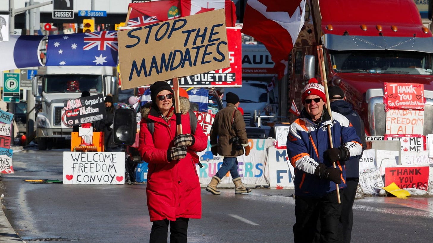 Para pemotres berkumpul di jalanan Ottawa sambil membawa slogan-slogan.