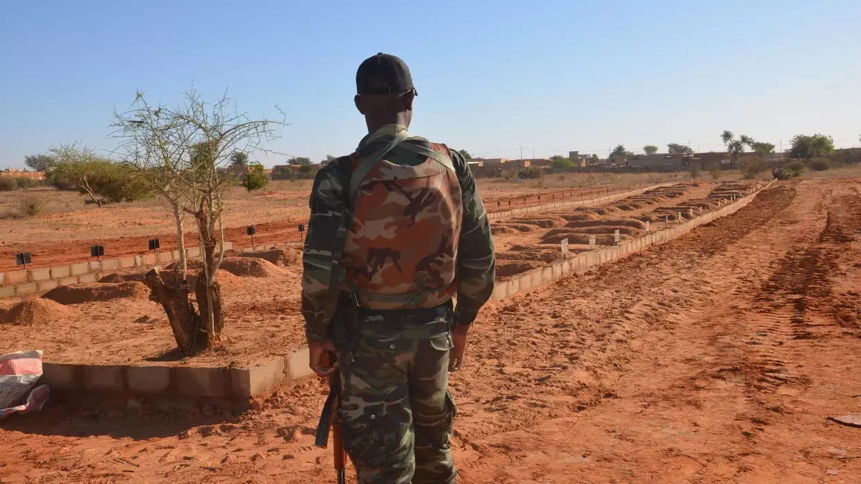 A Niger soldier looks at the graves of 71 Niger troops soldiers killed  in a jihadist attack on December 10, 2019, ahead of a regional summit to coordinate a response to the growing unrest.